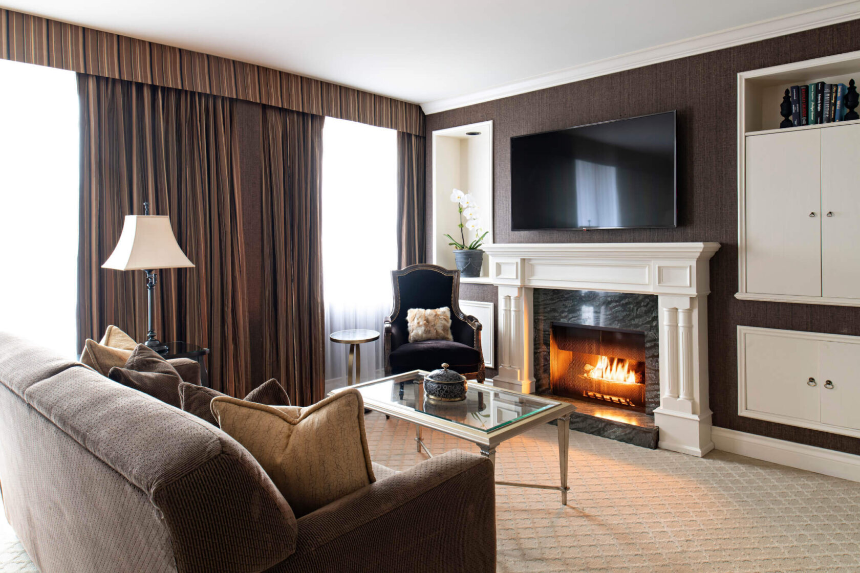 Penthouse Living room with fireplace, featuring British-Inspired Urban Décor with Accents of Silk, Leather, and Natural Grasscloth